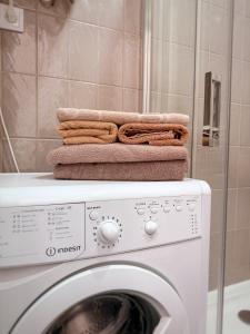 a stack of towels sitting on top of a washing machine at Kyiv Lesi 3 Studio Apartment in Kyiv