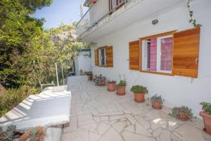 a patio with potted plants and a building at Robinson Erina in Zarače
