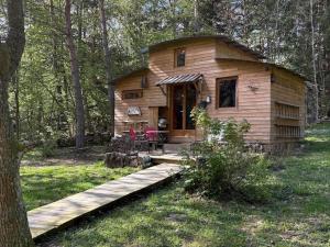 a log cabin in the woods with a wooden porch at Domaine de la Mamounette in Champclause
