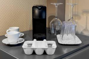 a black counter with cups and dishes and a blender at Salina Luxury Suites in Parma