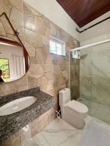a bathroom with a sink and a toilet and a mirror at Hotel e Pousada Martini in Sorriso