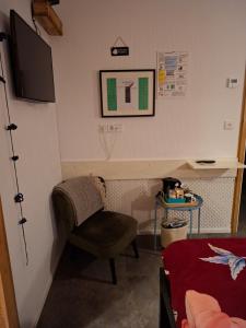 a small room with a chair and a bed at B&B Biej' oons tuus in Hellendoorn