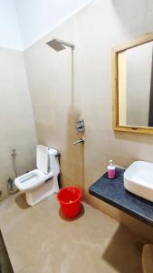 a bathroom with a toilet and a sink and a mirror at The Miraj Hotel in Murthal