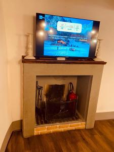 a flat screen tv sitting on top of a fireplace at La Torretta in Laterina