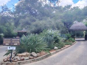 a sign in a garden with flowers and plants at The Lofts in Hoedspruit