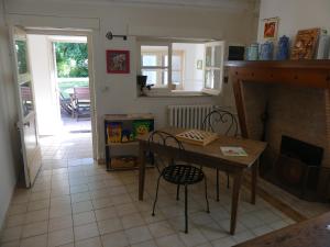a kitchen with a table and chairs and a fireplace at Gîte de la Grosse Planche in Férolles