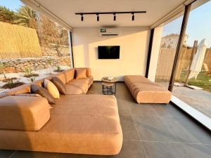 a living room with a couch and a tv at Dusk batroun in Batroûn