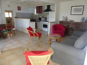 a living room with a couch and chairs and a kitchen at Gîte de la Grosse Planche in Férolles +4 photos