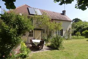 a house with a table and chairs in the yard at Gîte de la Grosse Planche in Férolles