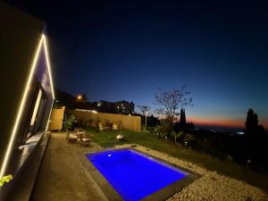a blue swimming pool in a backyard at night at Dusk batroun in Batroûn