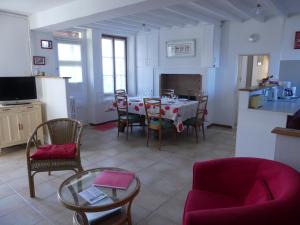 a living room with a table and chairs and a kitchen at Gîte de la Grosse Planche in Férolles