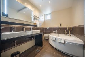 a bathroom with two sinks and a tub and a toilet at Hotel Sun Loznica in Loznica +49 photos