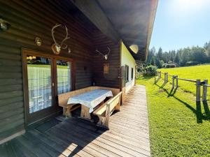 a porch of a wooden cabin with a bench on it at Almliesl KRIS-750 in Krispl