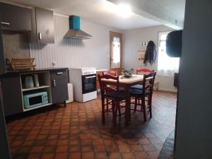 a kitchen with a table and chairs in it at Le Nichoir de Lesmont in Lesmont