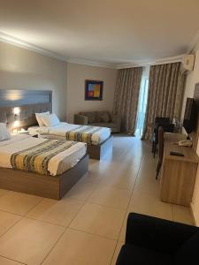 a hotel room with two beds and a couch at President Hotel in Jounieh
