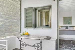a table with a bowl of fruit on a balcony at Niriides Beachfront Resort in Gythio