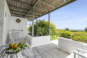 a patio with a table and a view of the ocean at Niriides Beachfront Resort in Gythio