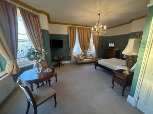 a bedroom with a bed and a table and chairs at Ashleigh Buxton in Buxton
