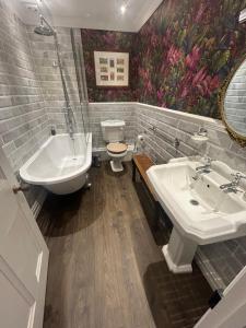 a bathroom with a sink and a tub and a toilet at Ashleigh Buxton in Buxton +27 photos
