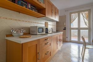a kitchen with a counter top with a microwave at Casetta Di Denny in Polignano a Mare +29 photos
