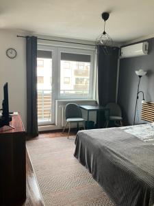 a bedroom with a bed and a desk and a window at Szybowników 2 in Piła +8 photos