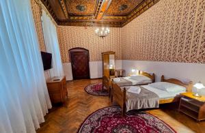 a bedroom with two beds and a tv in it at Zamek Otmuchów in Otmuchów +46 photos