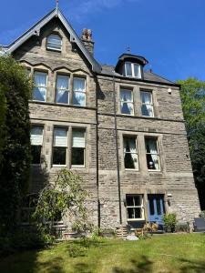 an old brick house with windows and a roof at Ashleigh Buxton in Buxton