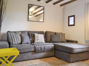 a living room with a couch and a mirror at The Nook in Amroth