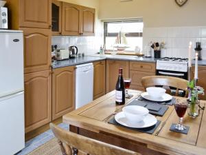 a kitchen with a wooden table with a bottle of wine at The Nook in Amroth