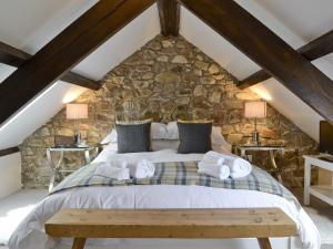 a bedroom with a large bed in a stone wall at The Nook in Amroth