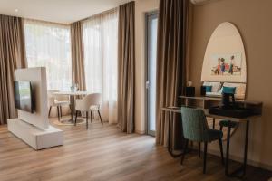 a living room with a television and a table with chairs at LKL Lakeside Lodging in Paratico