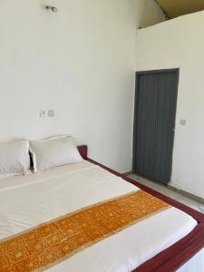 a white room with two beds and a black door at O'Sole Mio Assinie - La résidence in Assinie