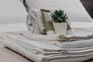 a pile of towels and a plant on a bed at Salina Luxury Suites in Parma +40 photos