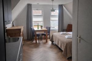 a small room with a bed and a table with chairs at Boutique Hotel De Grote Kade in Goes