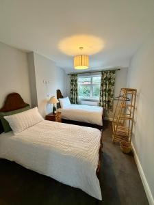 a bedroom with two beds and a ladder and a window at Unique Vicarage Town Cottage in Leominster
