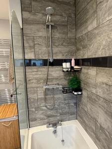 a bathroom with a shower and a bath tub at Unique Vicarage Town Cottage in Leominster