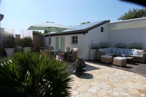 a patio with a couch and an umbrella at La Maison d'Adonis à la mer in Crozon