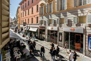 a group of people walking down a street with buildings at Salina Luxury Suites in Parma