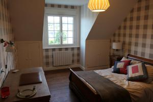 a bedroom with a bed with a table and a window at La Maison d'Adonis à la mer in Crozon