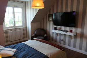 a bedroom with a bed and a television on the wall at La Maison d'Adonis à la mer in Crozon +8 photos