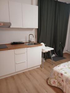 a kitchen with white cabinets and a sink and a bed at DESDEMA & OPERA Rooms in Quinto di Treviso