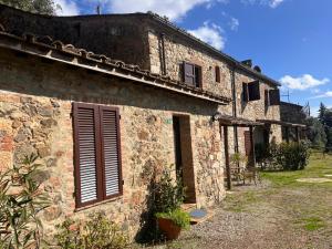 an old stone building with shutters on it at LA GRANCIA DEL SANTO in Monticiano