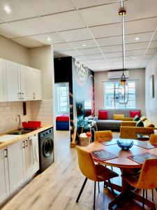 a kitchen and living room with a table and a dining room at Pepper Korrel - Paarl - Self Catering Apartment in Paarl