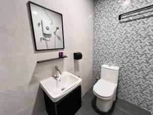 a bathroom with a white toilet and a sink at AURELIA Stay in Brinchang +36 photos