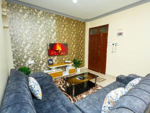 a living room with a blue couch and a tv at Heavenly homes apartment in Mombasa