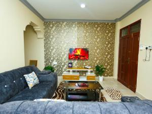 a living room with a blue couch and a tv at Heavenly homes apartment in Mombasa