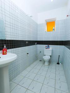 a blue tiled bathroom with a toilet and a window at Heavenly homes apartment in Mombasa +20 photos