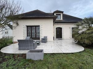a patio in front of a house with two chairs at La Changéenne - Maison de charme - 12 pers in Changé