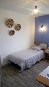 a bedroom with a bed and two plates on the wall at Les Clés Nature Studio 42 in Moutiers-sous-Chantemerle