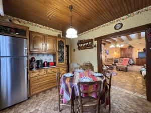 a kitchen with a table and a refrigerator at La Changéenne - Maison de charme - 12 pers in Changé